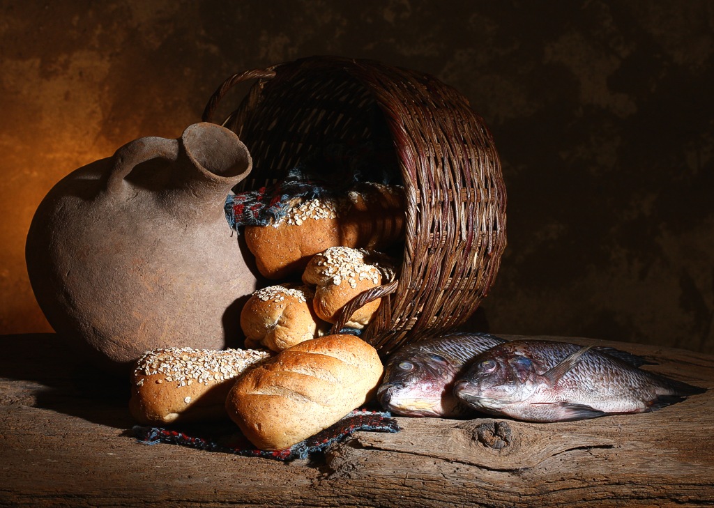 5 loaves of bread and 2 fish in front of a basket